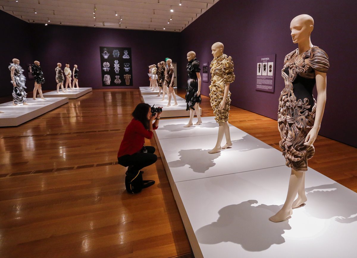 Una mujer toma fotografías de las prendas de la diseñadora holandesa Iris van Herpen que hacen parte de la exposición "Iris van Herpen: transformando la moda". (Foto Prensa Libre: EFE).