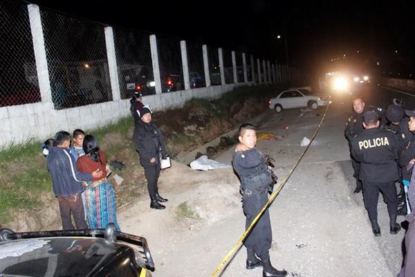 Autoridades y vecinos observan los cadáveres de las dos mujeres, en el km 61, ruta Interamericana, hacia el occidente del país. (Foto Prensa Libre: Víctor Chamalé)