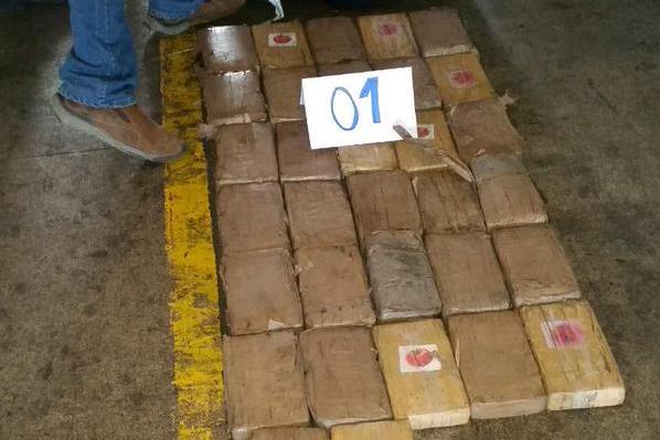 Paquetes con posible droga son contabilizados por investigadores de la PNC en Portuaria Santo Tomás de Castilla, Puerto Barrios, Izabal. (Foto Prensa Libre: PNC)