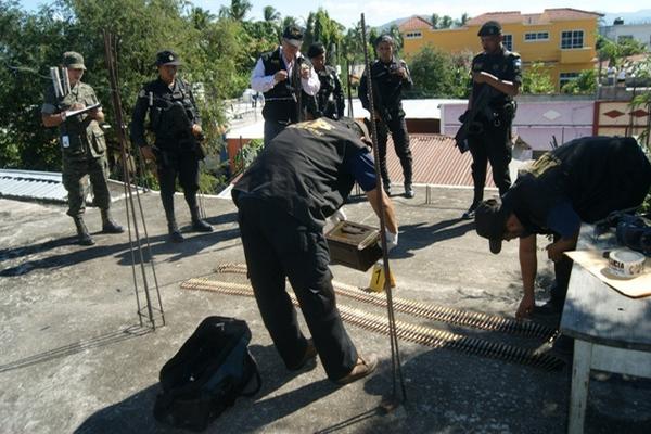 Fiscales del Ministerio Público y agentes de la PNC revisan el área donde fueron localizadas la municiones. (Foto Prensa Libre: Edwin Paxtor)<br _mce_bogus="1"/>