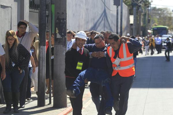 Socorristas atiende a un herido durante las tareas de rescate de terremoto. (Foto Prensa Libre: E. Bercian )