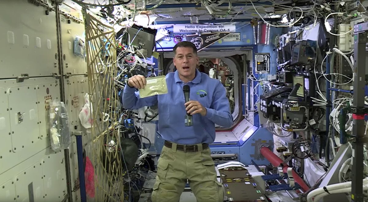 El astronauta de la Nasa, Shane Kimbrough, muestra una bolsa que contiene carne del pavo que preparará su tripulación el jueves próximo. (Foto Prensa Libre: AP).
