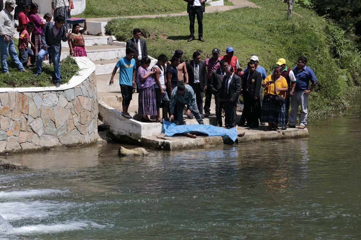 Curiosos observan el cadáver del estudiante que se ahogó en San Pedro Carchá. (Foto Prensa Libre: Eduardo Sam).