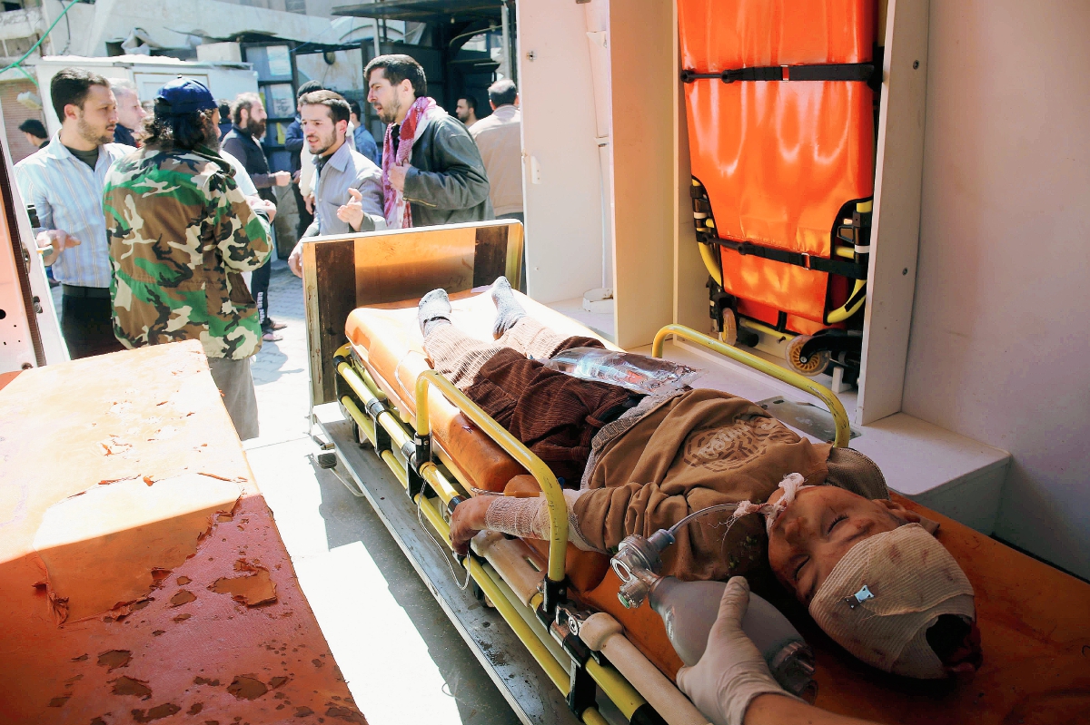 Un niño herido yace en una camilla dentro de una ambulancia. Los ataques del Gobierno a los rebeldes han dejado múltiples civiles heridos. (Foto Prensa Libre. AP).