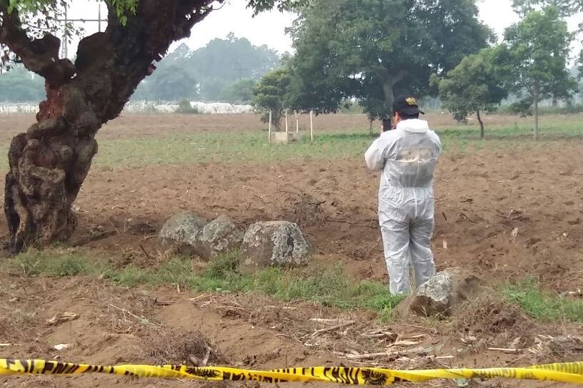 Investigadores policiales examinan terreno donde fue localizado el cuerpo carbonizado de una mujer, en la cabecera de Chimaltenango. (Foto Prensa Libre: Víctor Chamalé)