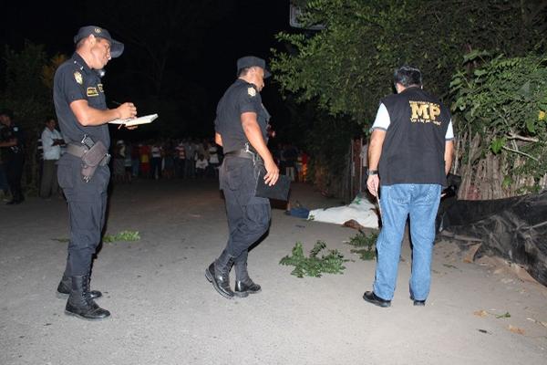 Los cadáveres quedaron en la entrada de la tienda Margoth. (Foto Prensa Libre: Alexánder Coyoy)