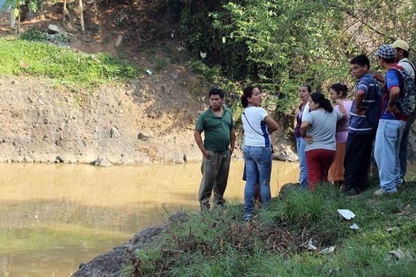 Curiosos observan el lugar donde fue encontrado el cadáver de Juan Carlos Borgas, en Retalhuleu. (Foto Prensa Libre: Rolando Miranda)