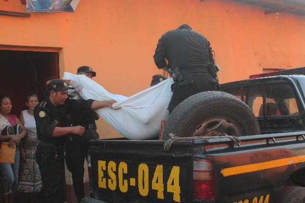 Agentes de la Policía trasladan el cuerpo de  Juan Armando López González, quien   murió baleado en Tiquisate, Escuintla, el domingo último.