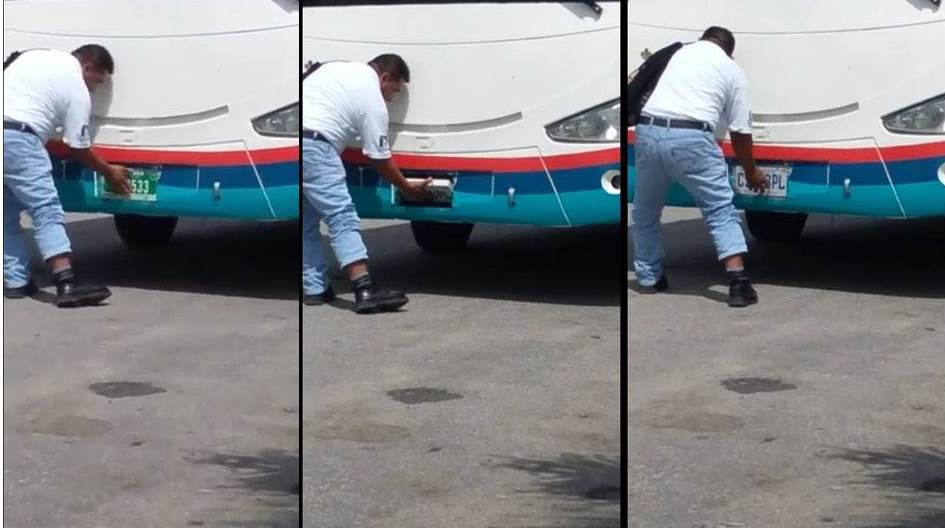 Un hombre rota las placas de circulación de un autobús, captado en un paso fronterizo entre Belice y Petén. (Foto Prensa Libre: Facebook)