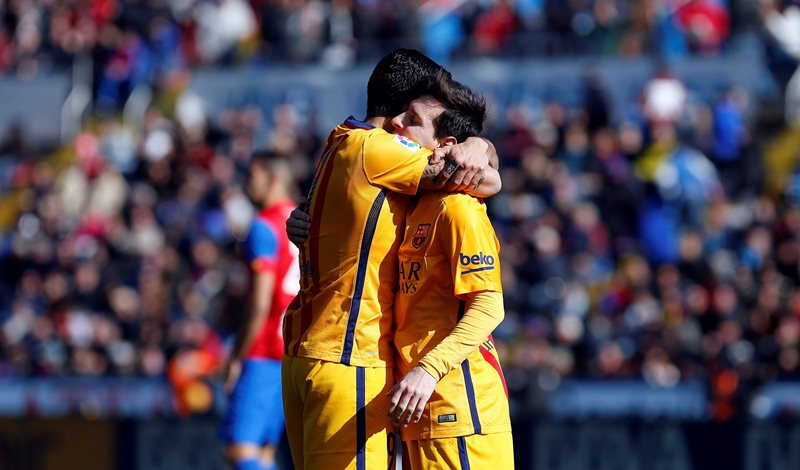 Luis Suárez abraza a su compañero de goles, Lionel Messi, y celebra su anotación. (Foto Prensa Libre: EFE)