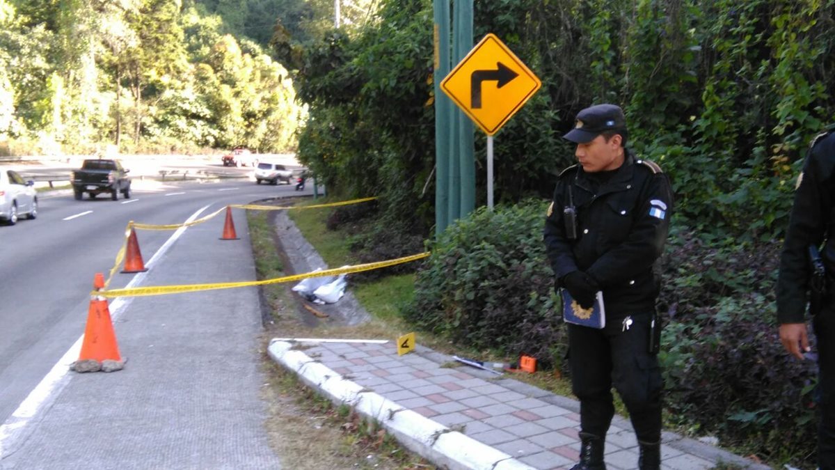 Policías resguardan escena en el kilómetro 24 de la ruta Interamericana, lugar en el que fue encontrado el cadáver. (Foto Prensa Libre: Estuardo Paredes)