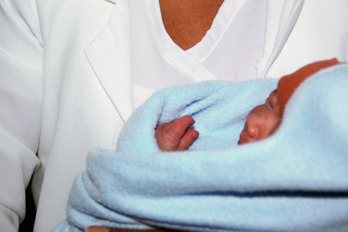 El bebé rescatado es protegido por una enfermera en el Hospital Regional de Huehuetenango. (Foto Prensa Libre: Mike Castillo)