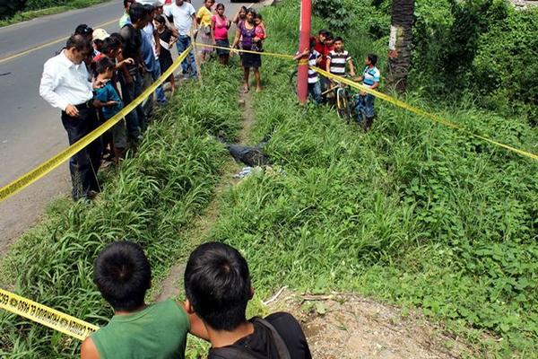 Curiosos observan el lugar donde quedó el agente Richard Seuleman Güinac Oxlaj, tras haber sido atropellado en Santa Cruz Muluá. (Foto Prensa Libre: Rolando Miranda)