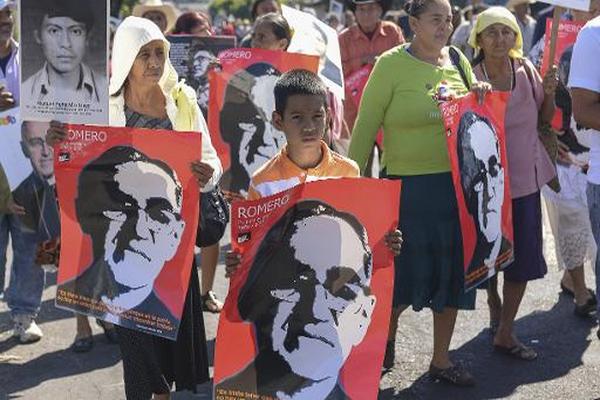 Miembros de una organización de derechos humanos, civiles y sociales  sostienen afiches del asesinado arzobispo Óscar Arnulfo Romero. (Foto  Prensa Libre: AFP)