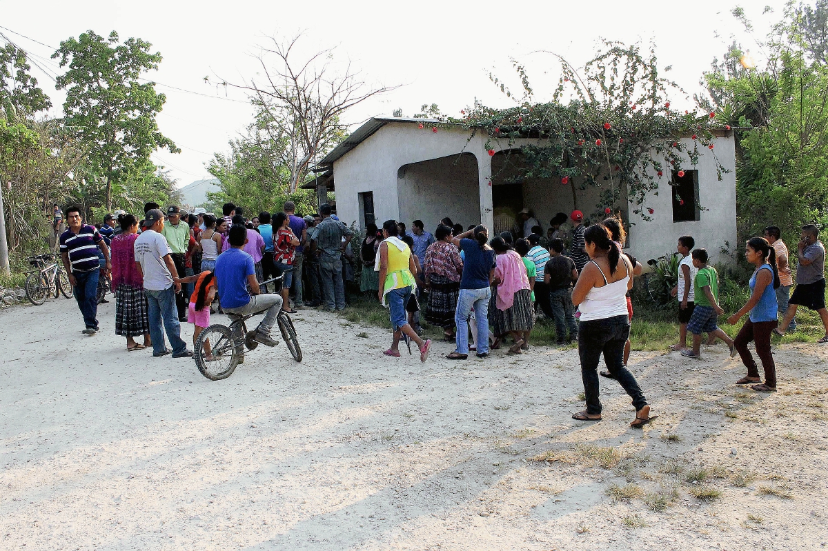 Pobladores de  Poptún, Petén, observan la vivienda donde fue atacada una familia y murieron tres. (Foto Prensa Libre: Walfredo Obando)