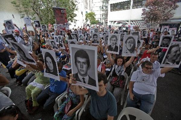  Manifestantes muestran fotografías de los desaparecidos del golpe militar en 1964. (Foto Prensa Libre:EFE)