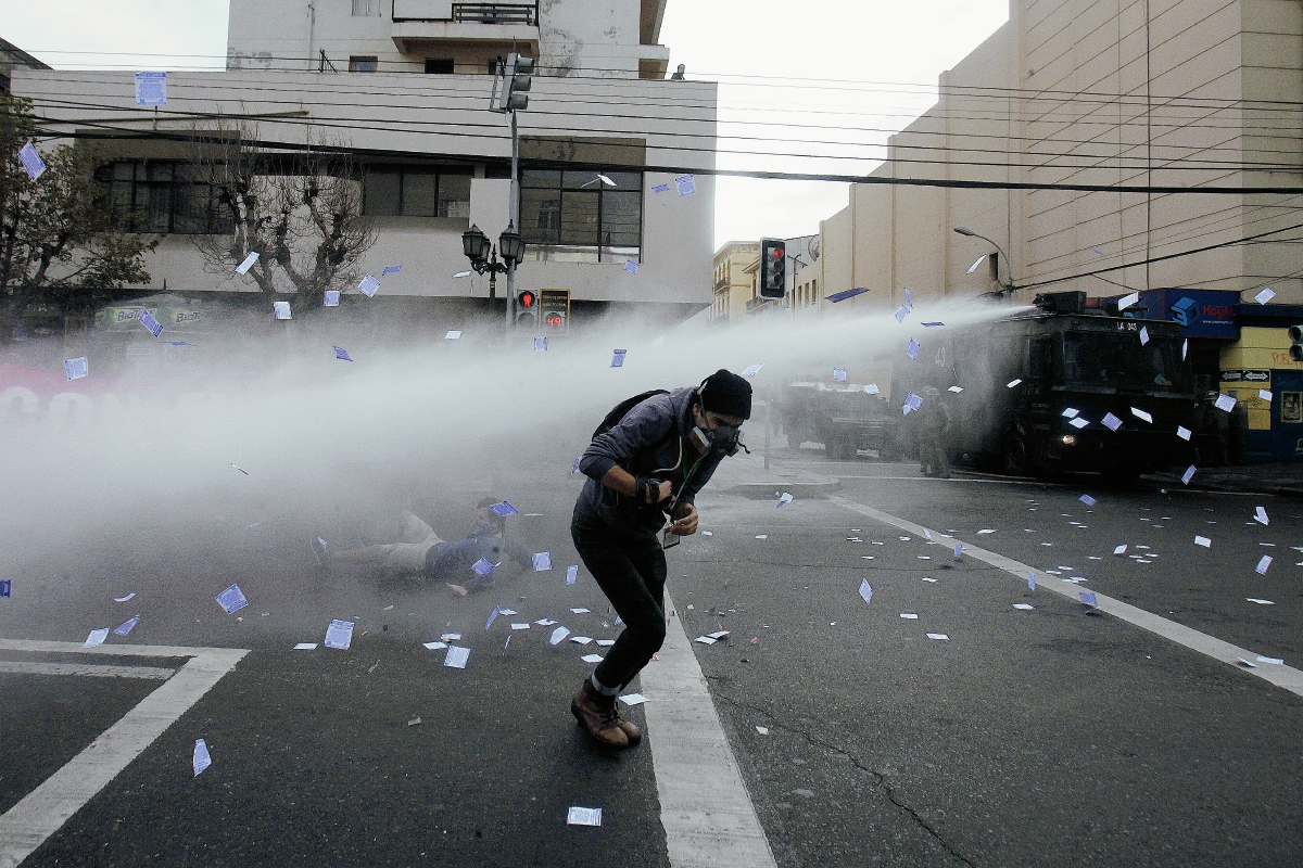 Manifestantes son dispersados con agua por las autoridades chilenas. (Foto Prensa Libre:EFE)