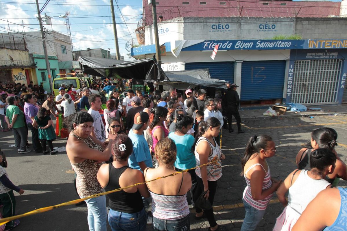 Comerciantes y compradores observan la escena del doble crimen. (Foto Prensa Libre: Erick Ávila)