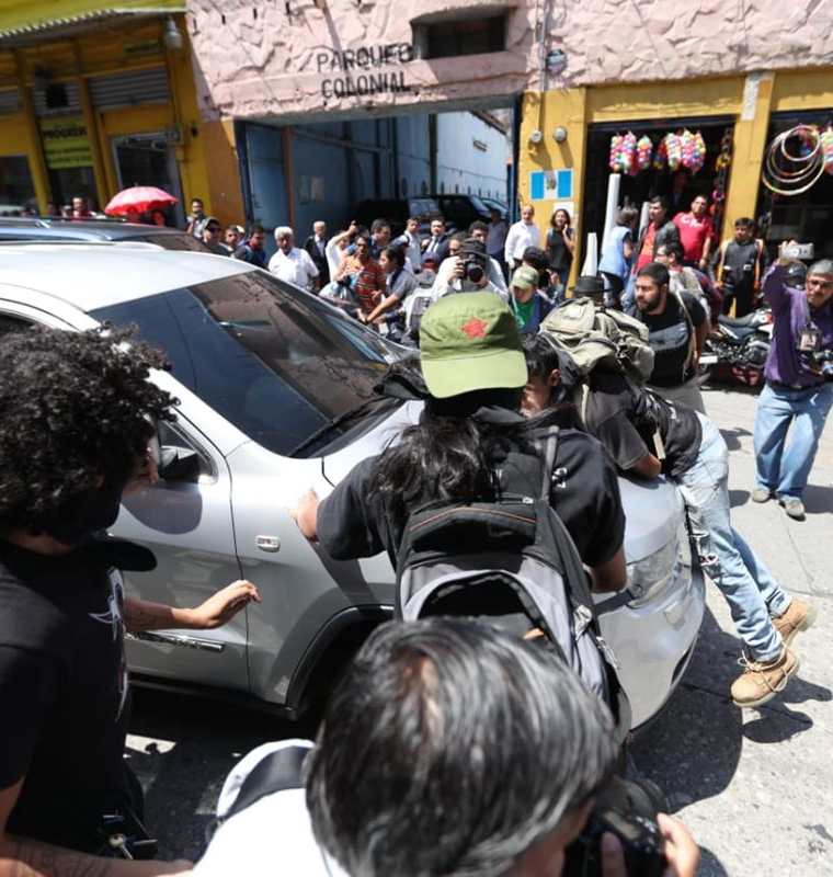 Uno de los manifestantes se subió al bumper del vehículo para evitar que el ministro de Salud huyera del lugar. (Foto Prensa Libre: Esbin García)