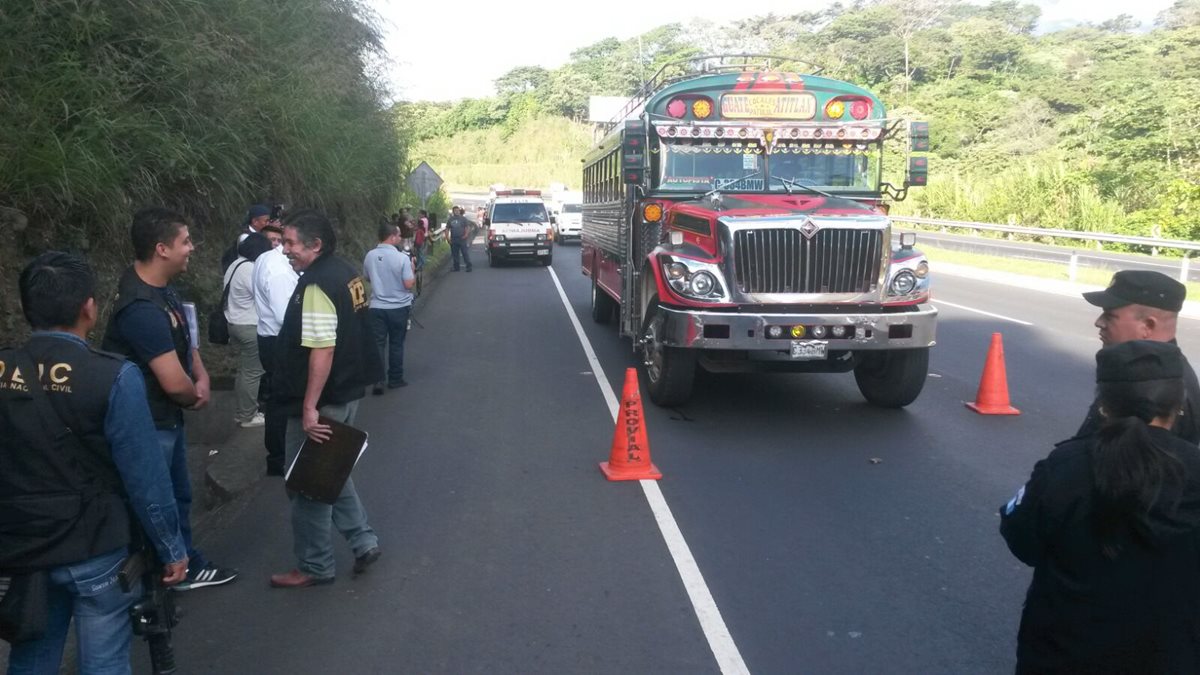 El autobús donde se perpetró el ataque contra un piloto es resguardado por agentes de la Policía Nacional Civil, en Palín, Escuintla. (Foto Prensa Libre: Carlos E. Paredes)