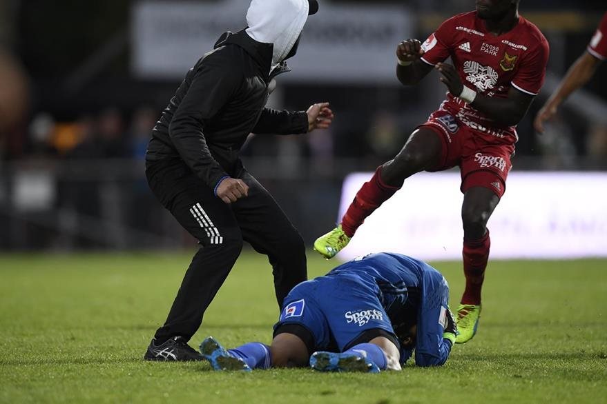 El portero de Ostersund Aly Keita se cubre la cabeza después de ser agredido por un aficionado. (Foto Prensa Libre: EFE)