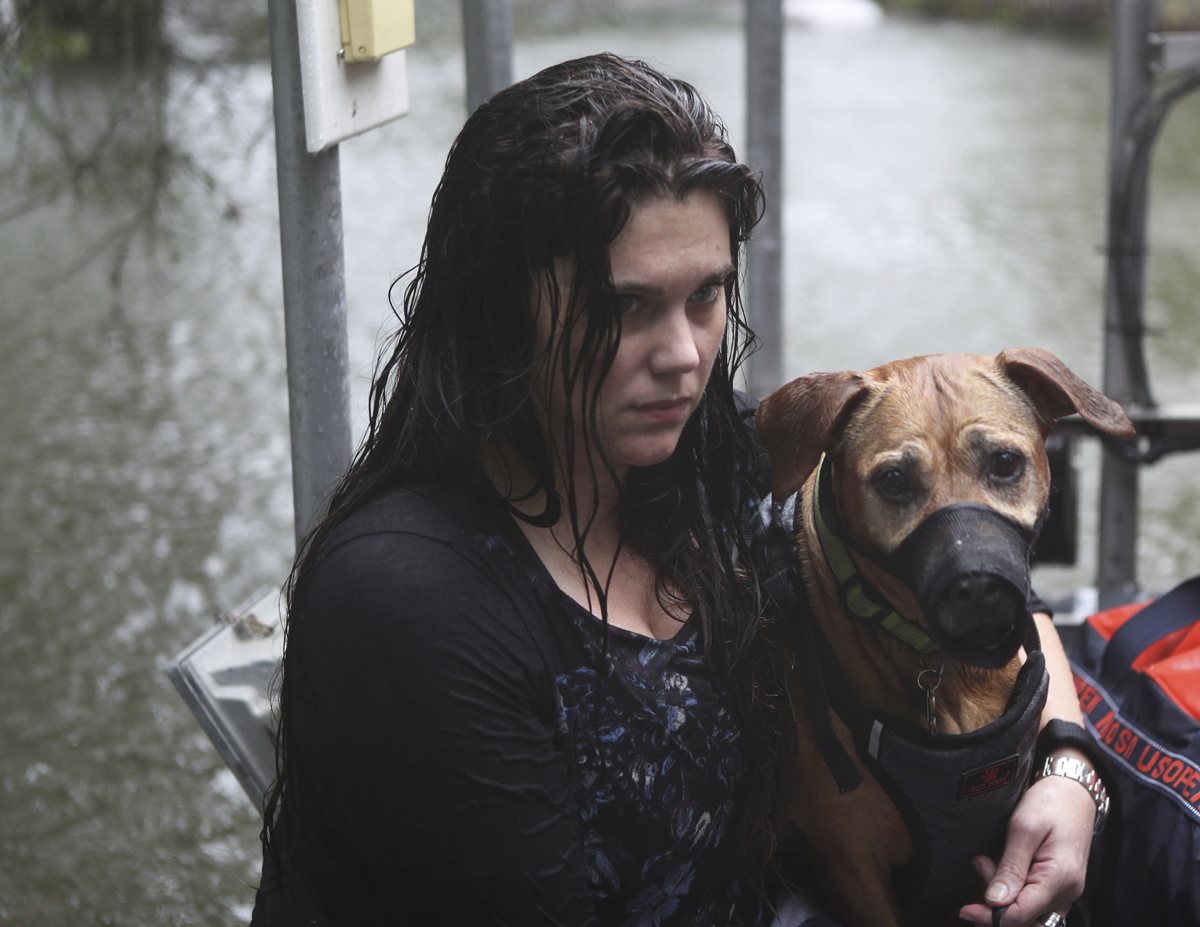 Celeste Johnston y su perro son evacuados de su casa de Dickinson, Texas.(AP).