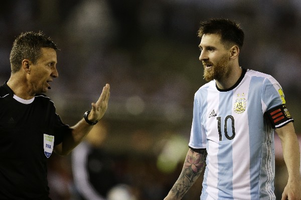 Leo Messi dialoga con el asistente arbitral Emerson Augusto de Carvalho al final del encuentro contra Chile. (Foto Prensa Libre: AP)