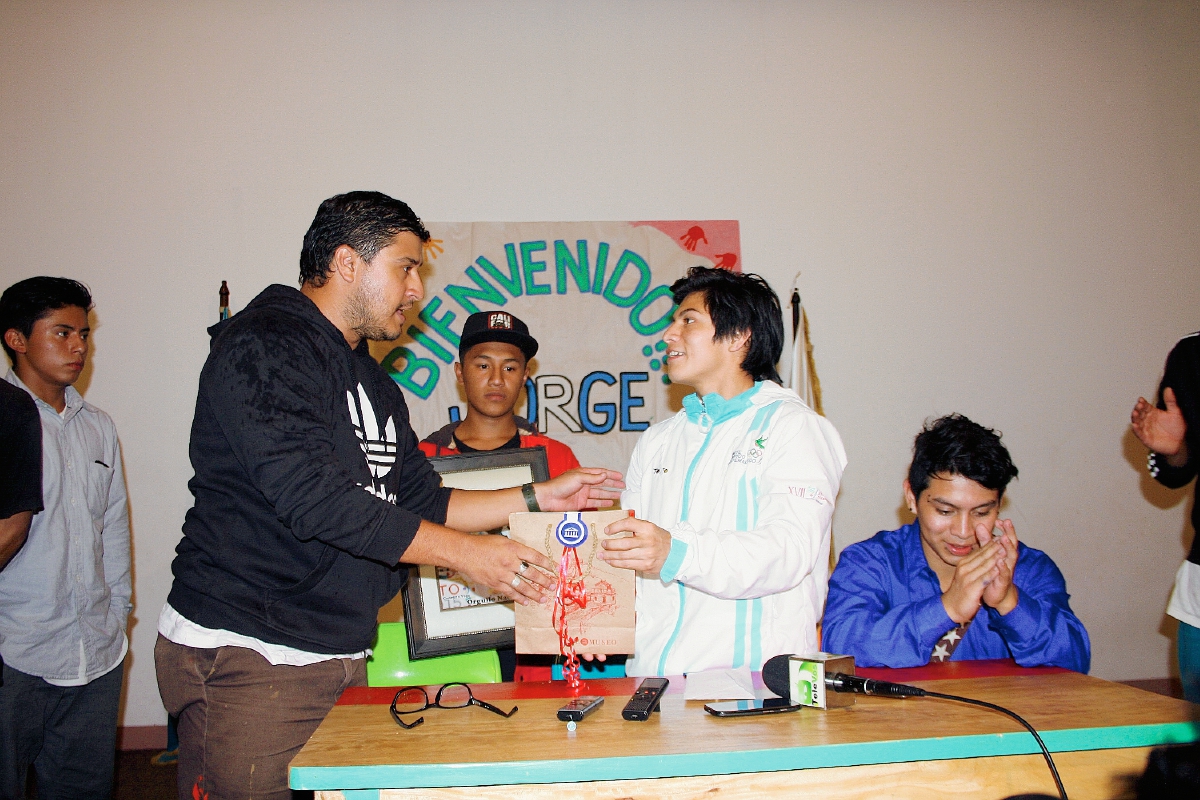 Juan Pablo Romero, le brinda reconocimientos a nombre de la asociación al medallista. (Foto Prensa Libre: Renato Melgar)