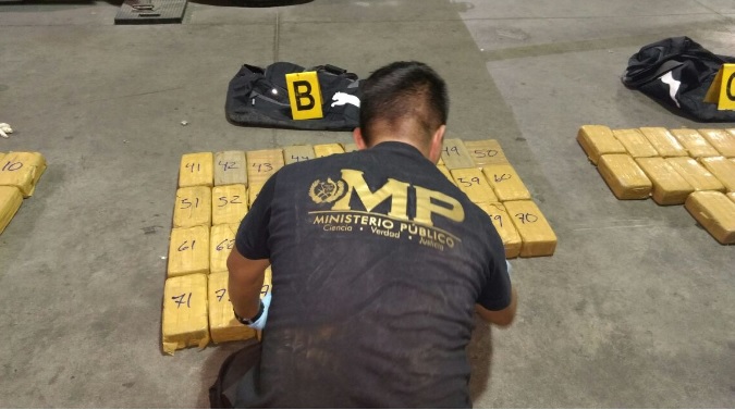Fiscal del MP contabiliza la cantidad de paquetes que se hallaron en uno de los maletines. (Foto Prensa Libre: Cortesía MP)
