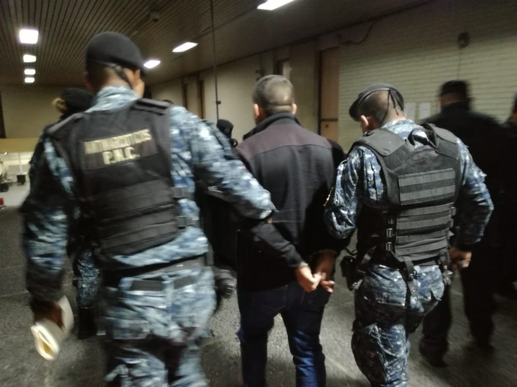 Agentes antinarcóticos trasladan a Tribunales a Julio César Orellana Cordón luego de capturarlo en el Aeropuerto Internacional La Aurora. (Foto Prensa Libre: PNC).
