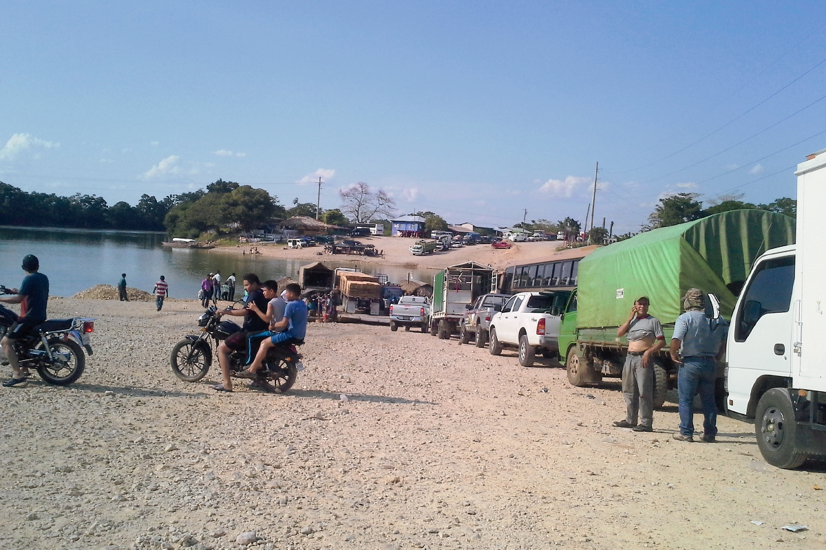 Larga fila de vehículos se forman para utilizar el ferry en Sayaxché, Petén. (Foto Prensa Libre: Rigoberto Escobar)