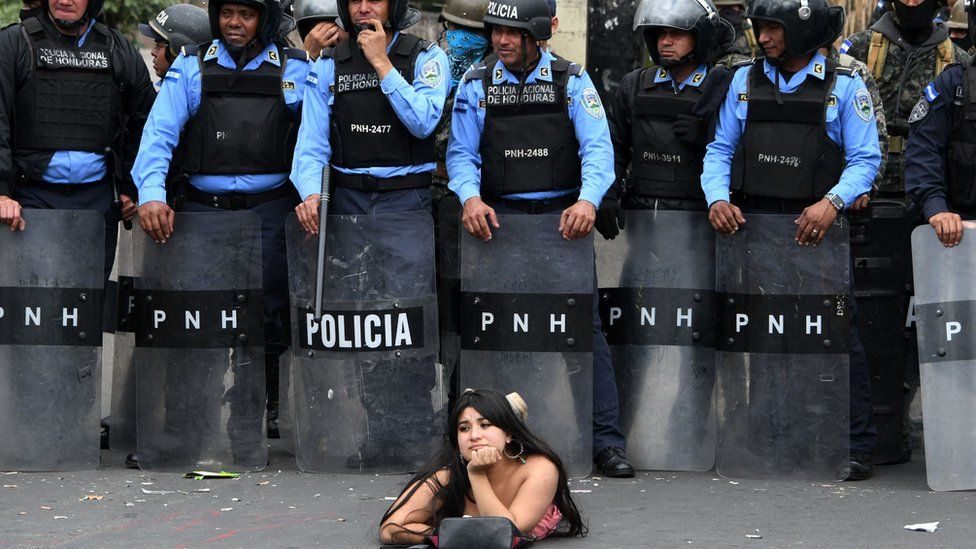 Una manifestantes se acuesta frente a la policía en una protesta contra la reelección del presidente Juan Orlando Hernández en Honduras. (Foto Prensa Libre:GETTY IMAGES)