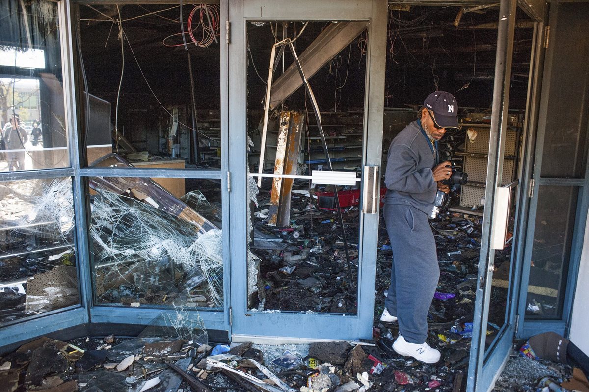 Un hombre sale de un local comercialq ue quedó destrozado tras los graves disturbios. (Foto Prensa LIbre:AFP).