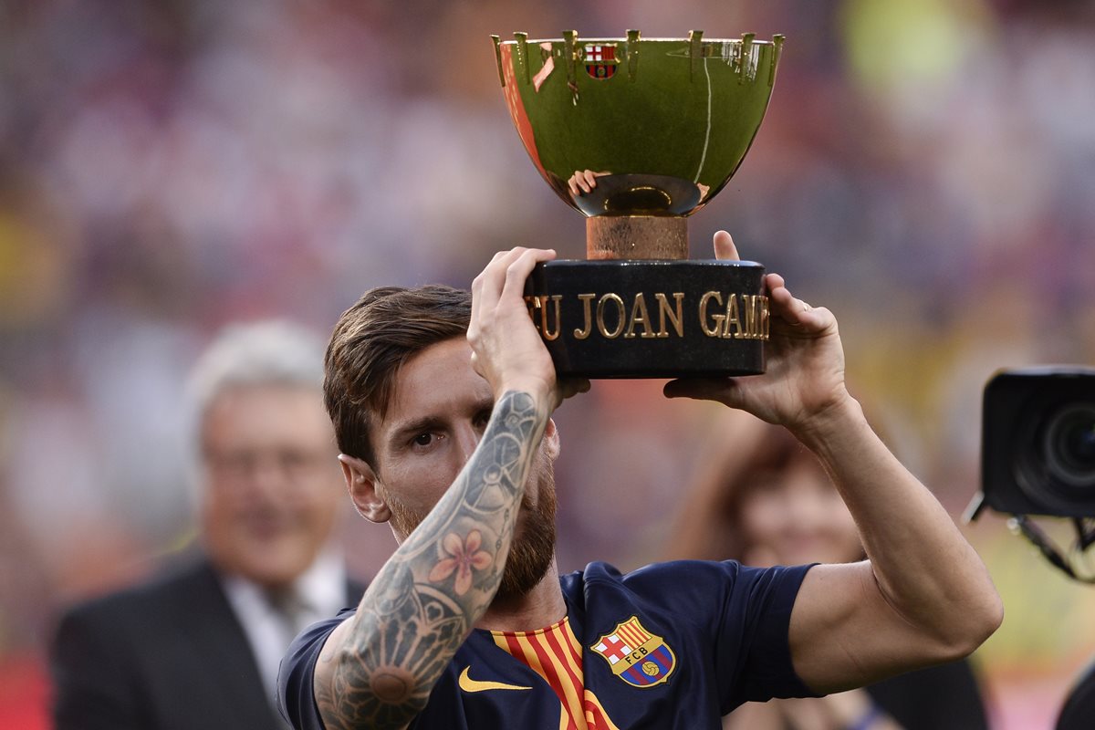 Lionel Messi levanta el Trofeo Joan Gamper. El argentino anotó el segundo gol del partido. (Foto Prensa Libre: AFP)