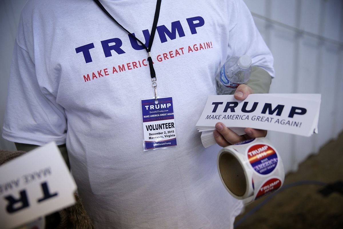 Una simpatizante de Donald Trump sostiene promocionales de la campaña rumbo a la presidencia de EE. UU. (Foto Prensa Libre: AFP).