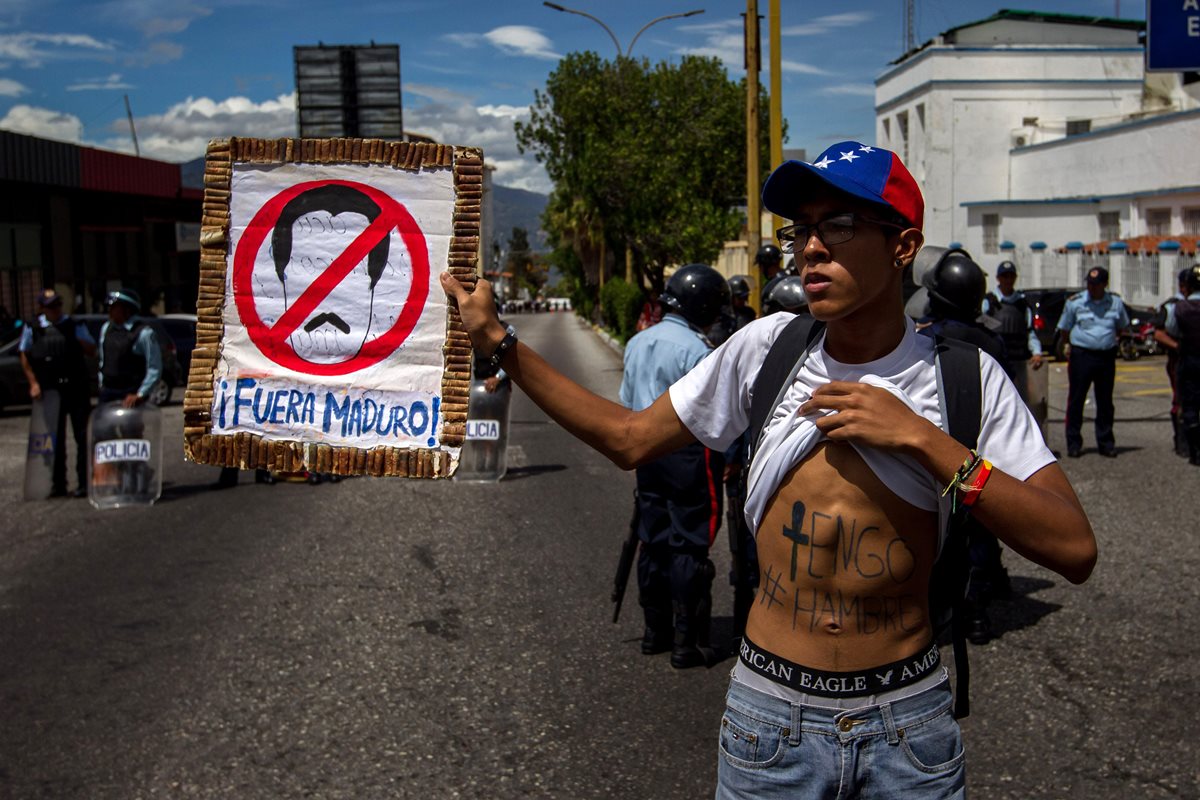 Un opositor del chavismo sostiene una pancarta en apoyo al referendo revocatorio contra el presidente Nicolás Maduro. (Foto Prensa Libre: EFE).