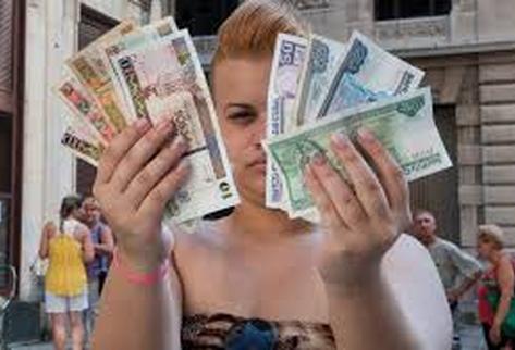 En la gráfica de archivo una vecina de La Habana muestra billetes cubanos de diferente denominación. (Foto Prensa Libre: AFP)