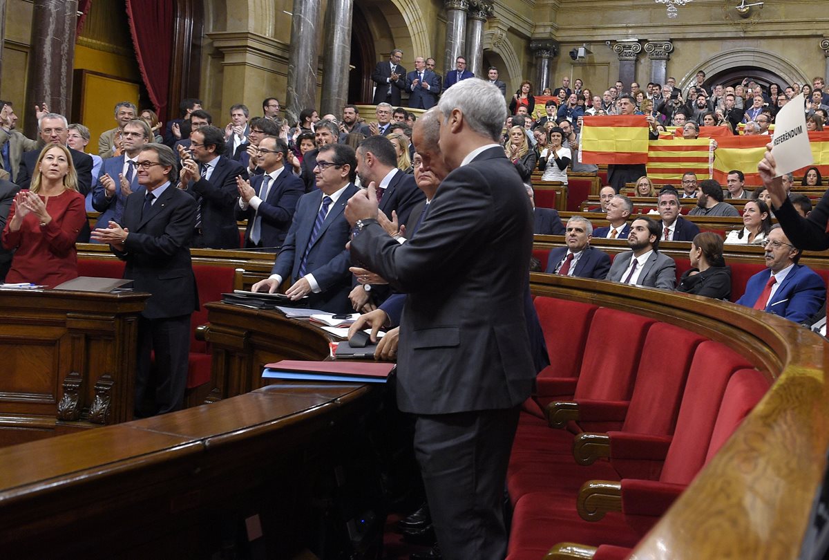 Diputados catalanes que apoyan la independencia de Cataluña, aplauden después de aprobada la resolución. (Foto Prensa Libre: AFP).