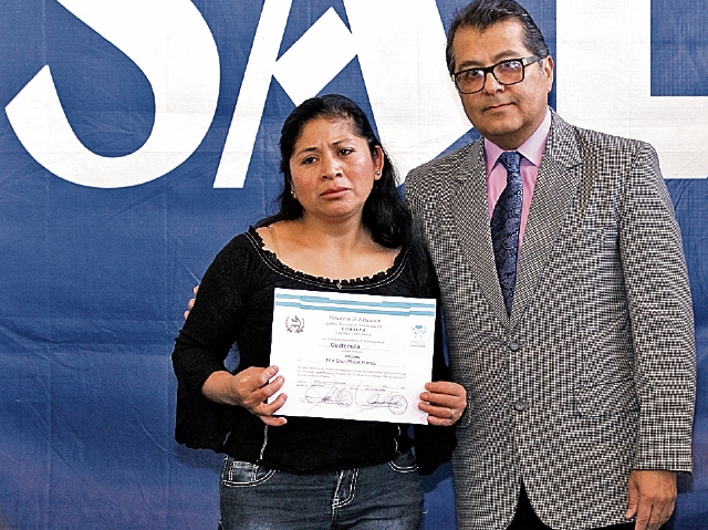 Lázaro Urizar, gerente de Circulación, entrega a Olga de Minas el diploma de su esposo, quien murió en un accidente. (Foto Prensa Libre: Álvaro Interiano)
