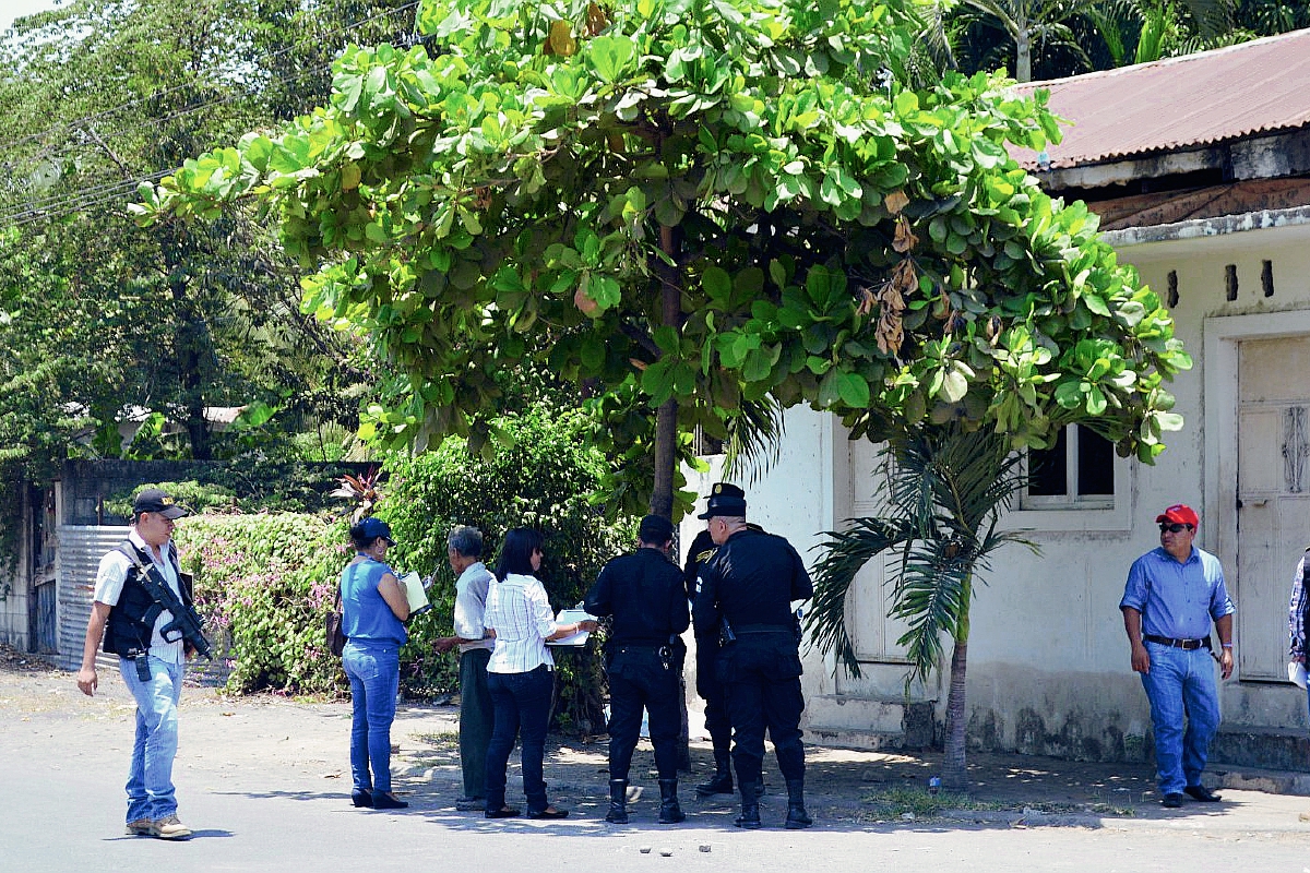 Fiscales del  Ministerio Público examinan la escena del crimen, donde una mujer murió baleada y un hombre resultó con heridas graves, en Puerto San José, Escuintla. (Foto Prensa Libre: Carlos Enrique Paredes)