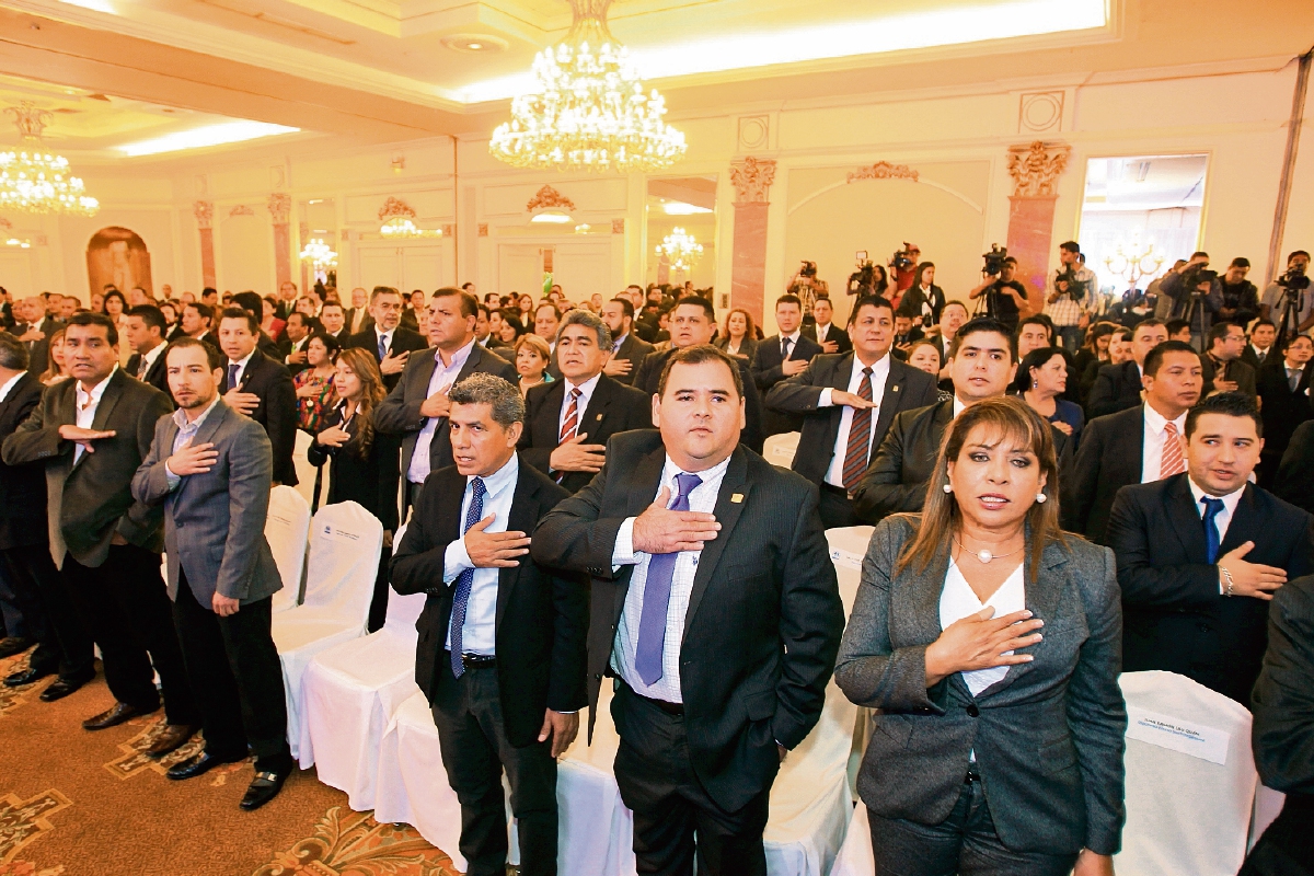 Los funcionarios que recibieron de los magistrados del TSE los documentos que los acreditan como servidores públicos cantan el himno nacional. (Foto Prensa Libre: Esbin García)