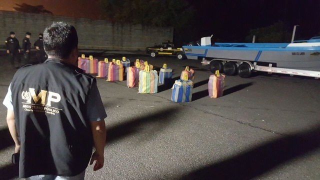 Un fiscal del Ministerio Público observa los paquetes con droga que fueron localizados en lancha interceptada en el Pacífico.(Foto Prensa Libre)