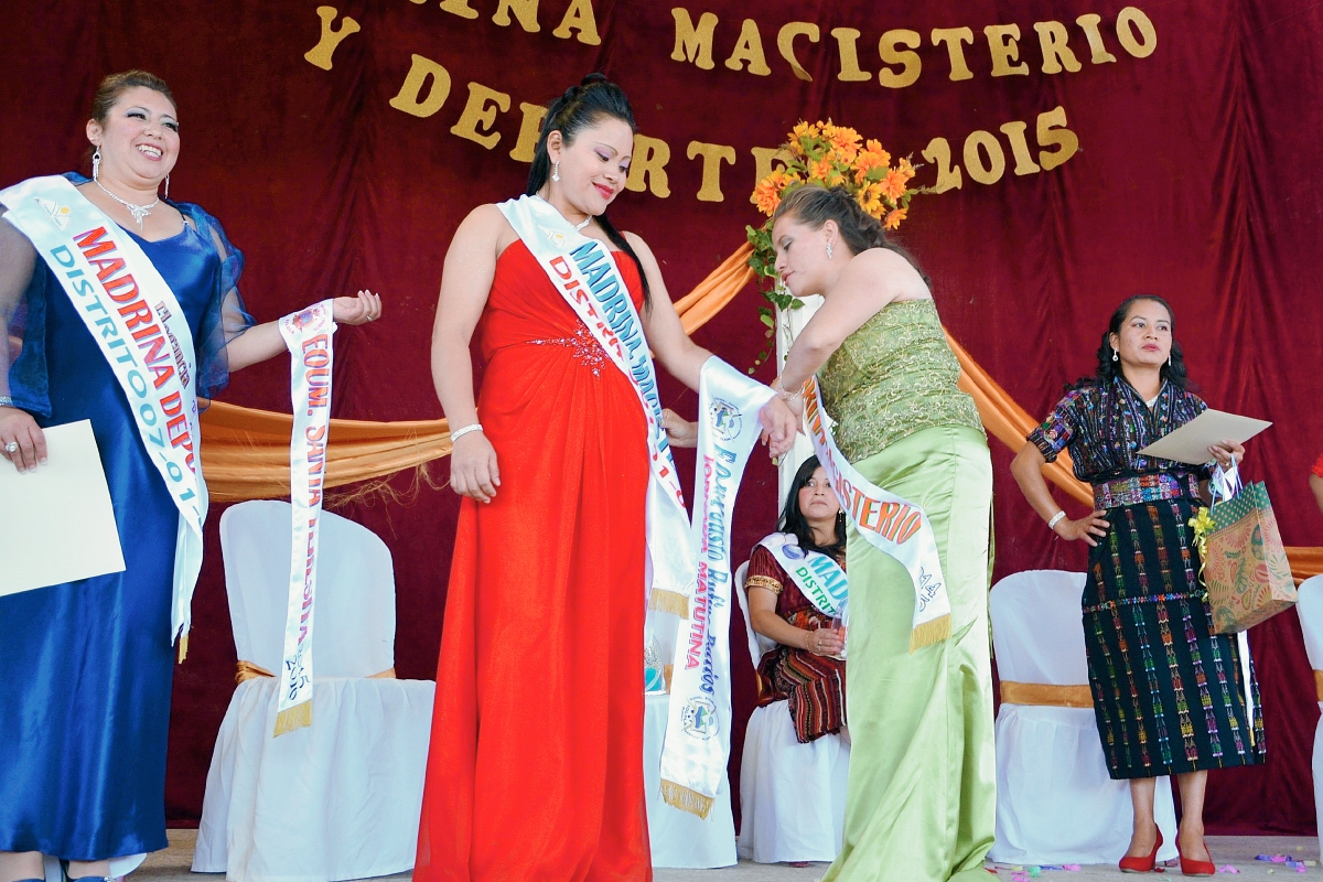 Mercedes Catalina de León -verde- reina saliente, inviste a Yoana de León como nueva Señorita Magisterio. A la izquierda Patricia Nohemy Gálvez, Señorita Deportes. (Foto Prensa Libre: Édgar Sáenz)