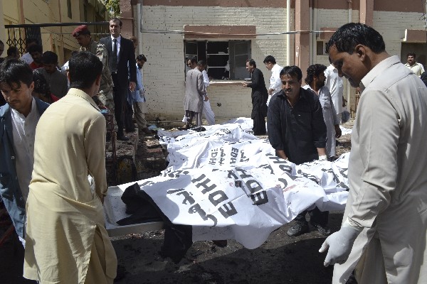 Voluntarios paquistaníes cubren los cuerpos de las víctimas de la explosión de una bomba.(Foto Prensa Libre:AFP).