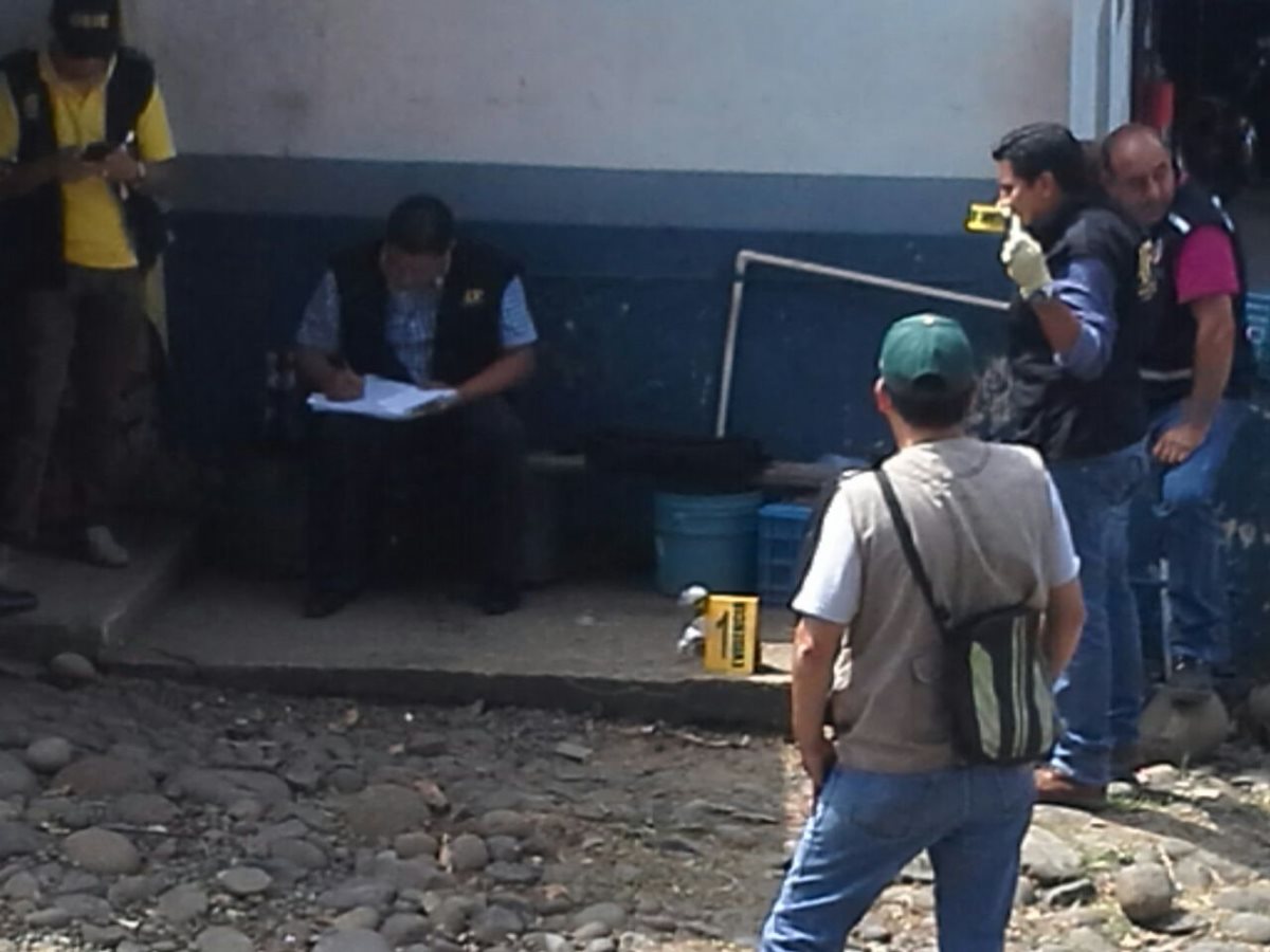 Fiscales del Ministerio Público y expertos en explosivos de la PNC analizan el artefacto. (Foto Prensa Libre: Alexánder Coyoy)
