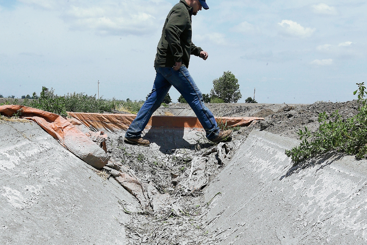 Un agricultor cruza un canal de riego que está cubierto de sal seca en Stockton, California.(Foto Prensa Libre:AP).