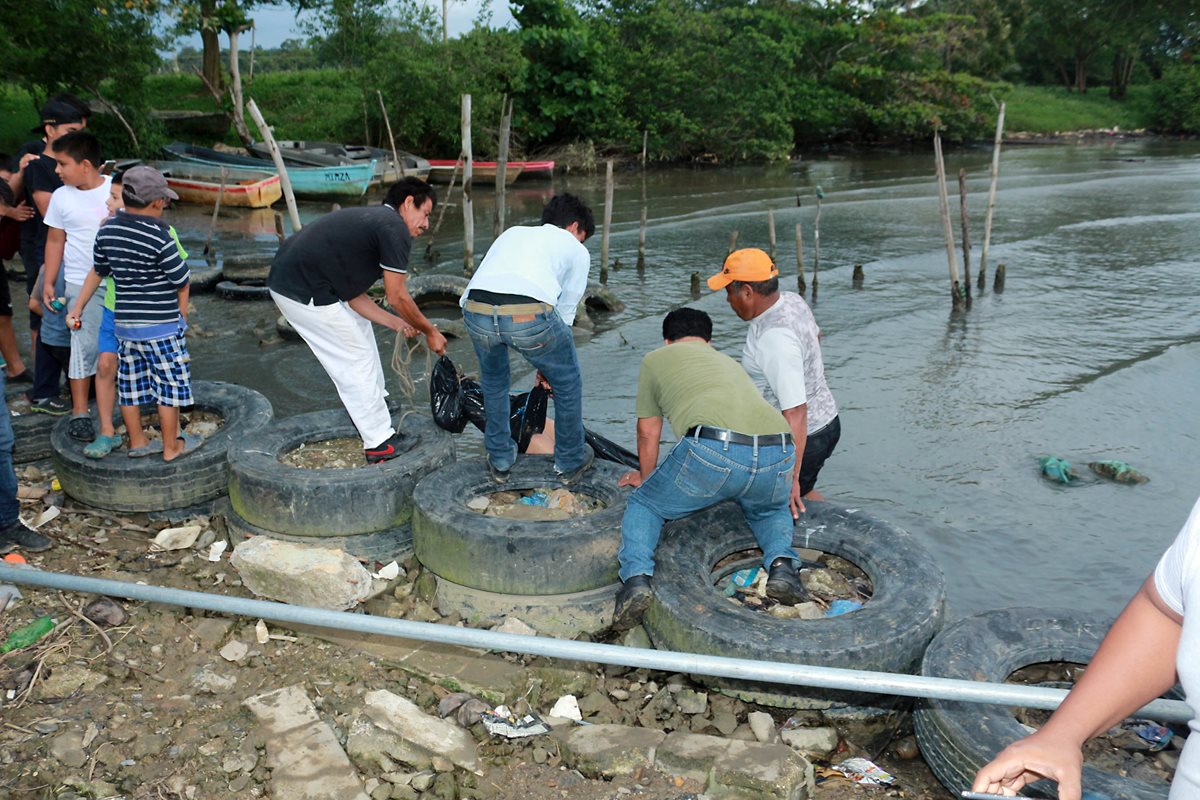 Vecinos del barrio El Limonar ayudar a extraer el cuerpo del mar. (Foto Prensa Libre: Dony Stewart)