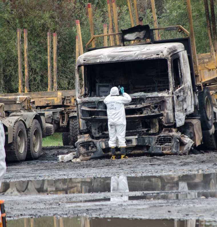 Policías inspeccionan el lugar donde fueron quemados 29 camiones. (EFE).