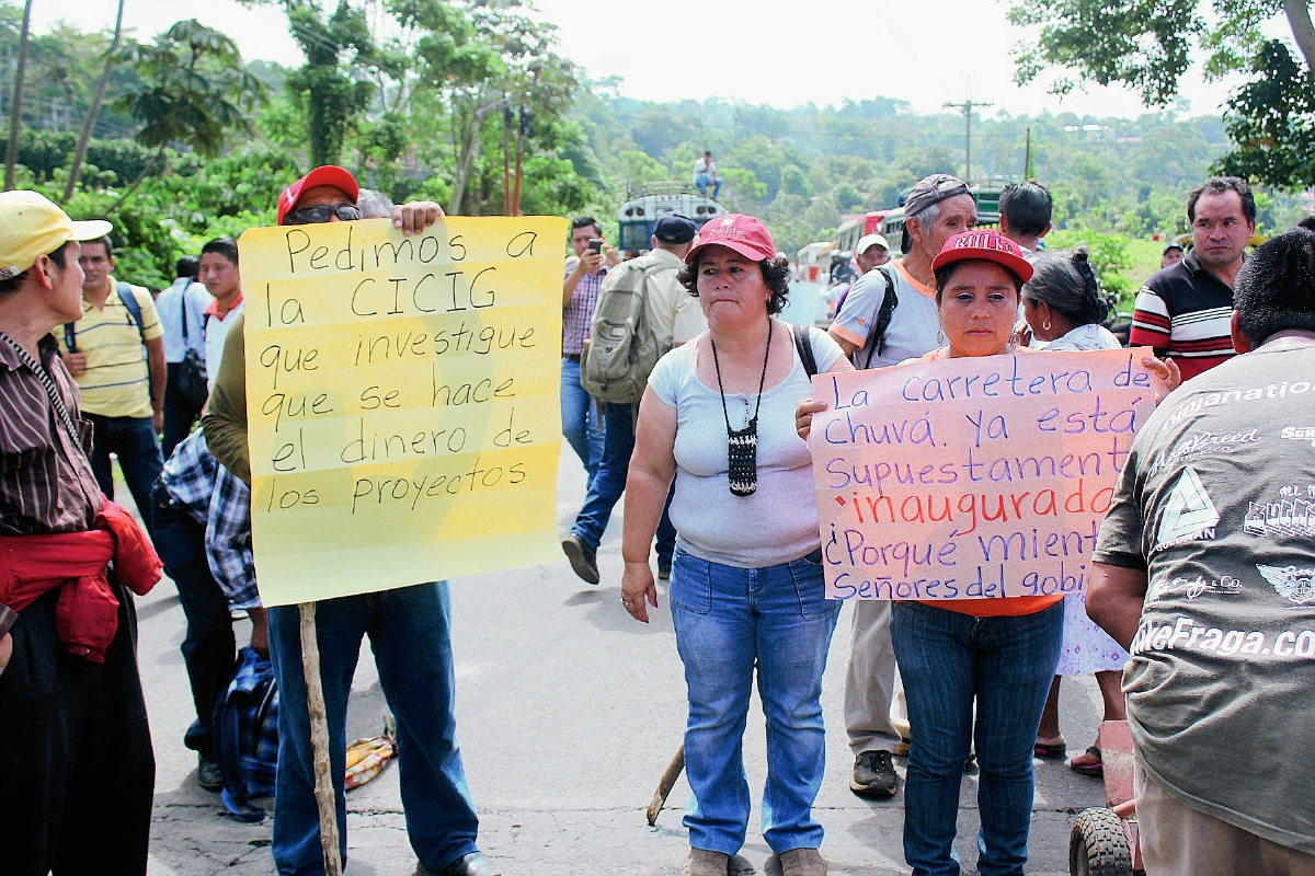 Pobladores de  Chuvá, Colomba, Quetzaltenango, muestran carteles durante bloqueo en el km 212.5 de la ruta a suroccidente. (Foto Prensa Libre: Alexánder Coyoy)