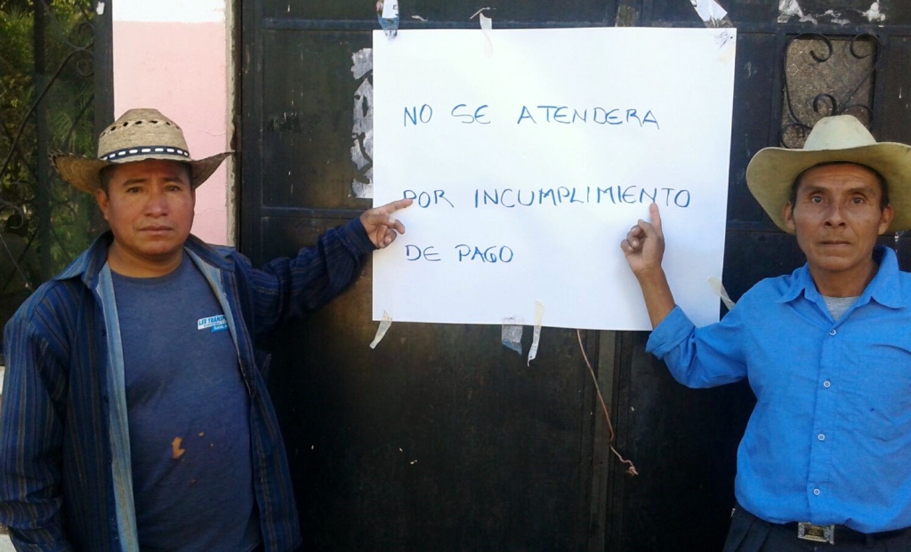 Dos empleados se manifiestan en el ingreso a la Municipalidad de Chicamán, Quiché, para exigir pago. (Foto Prensa Libre: Óscar Figueroa).